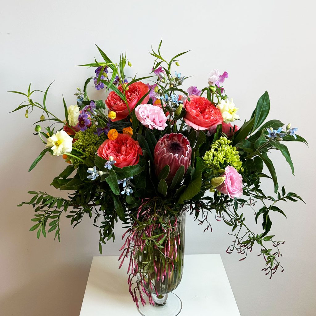 Deluxe Gem tier floral arrangement in a urn.